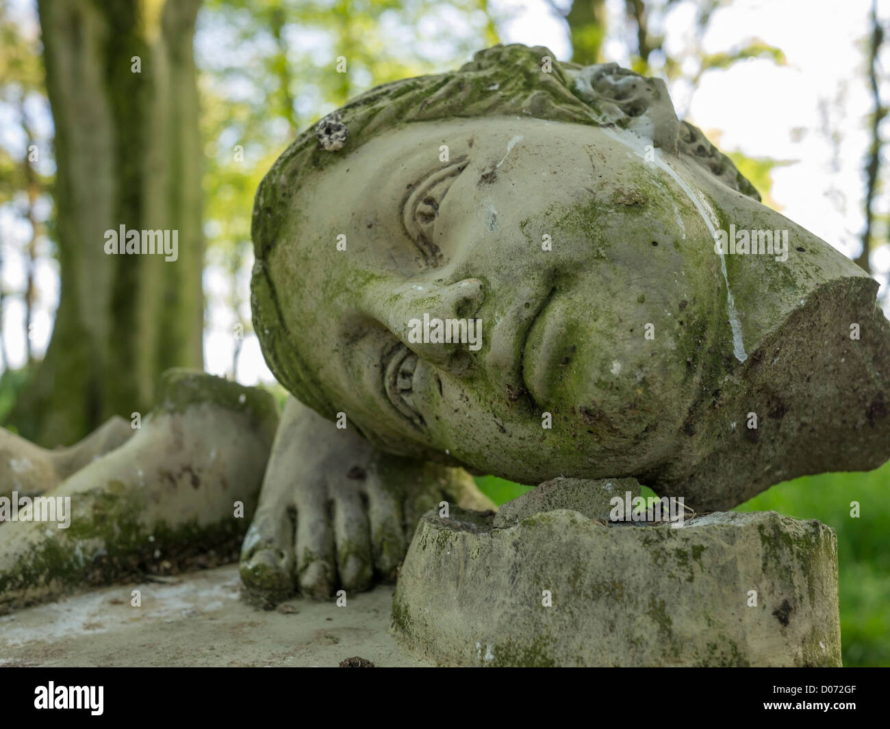 La tête et les pieds d'un jardin de pierres brisées sculpture dans un jardin anglais. Banque D'Images