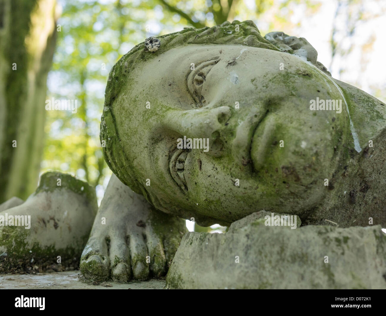 La tête et les pieds d'un jardin de pierres brisées sculpture dans un jardin anglais. Banque D'Images