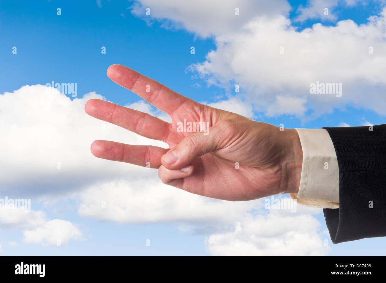 Mans part, montrant trois doigts, ciel nuageux fond de ciel bleu. Banque D'Images