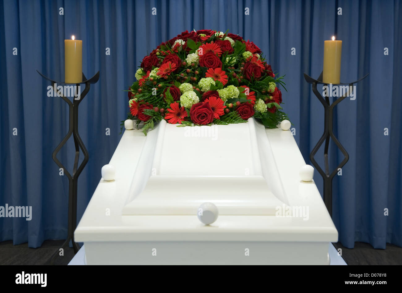 Un cercueil blanc dans une morgue avec un arrangement floral Banque D'Images