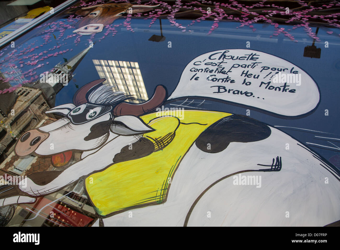 Une vache SUR VÉLO À BUTCHER'S SHOP PEINTURES SUR TOUR DE FRANCE DÉDIÉ WINDOWS (escale) VILLE VILLE MÉDIÉVALE SURNOMMÉE BONNEVAL Banque D'Images