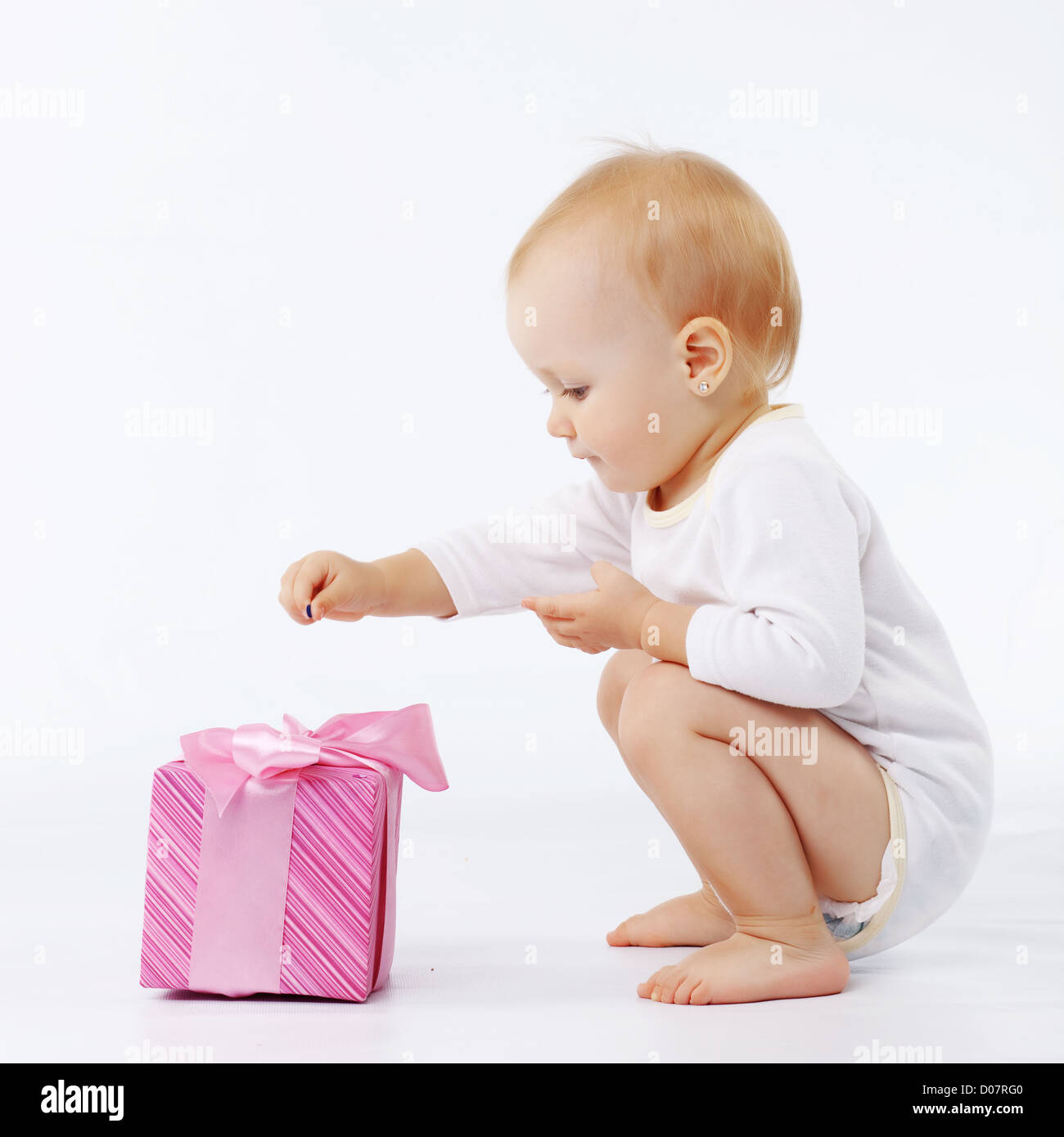 Portrait d'enfant ouvrant boîte-cadeau en blanc studio Banque D'Images