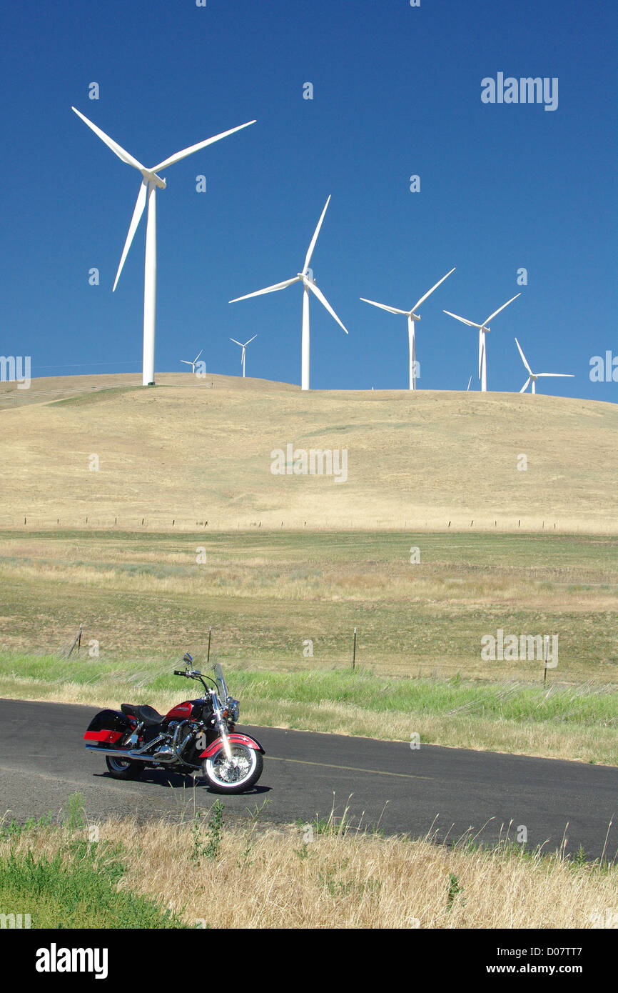 Une moto est garée en face d'une ferme éolienne de production d'énergie. Banque D'Images