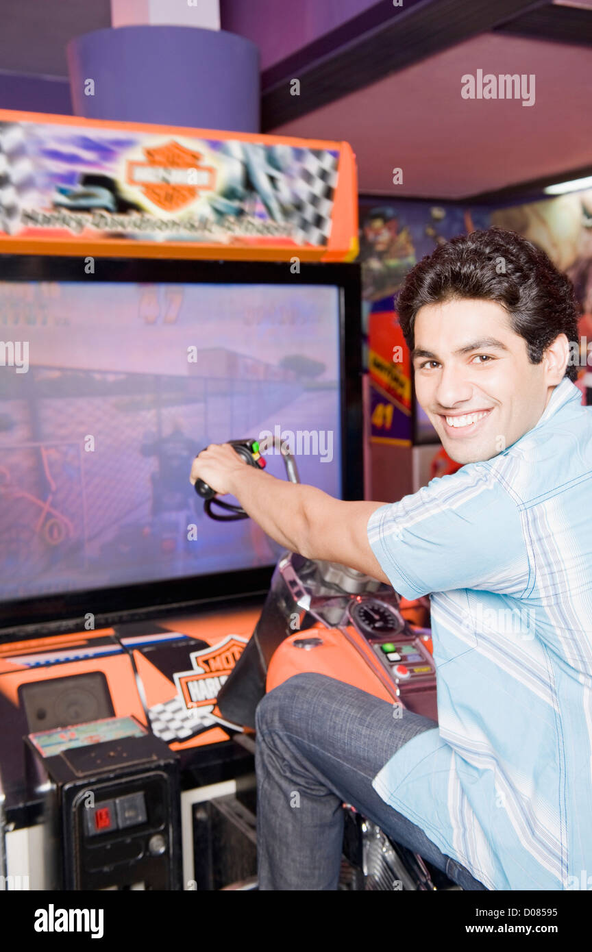 Jeune homme jouant jeu vidéo dans une salle de jeux vidéo Banque D'Images