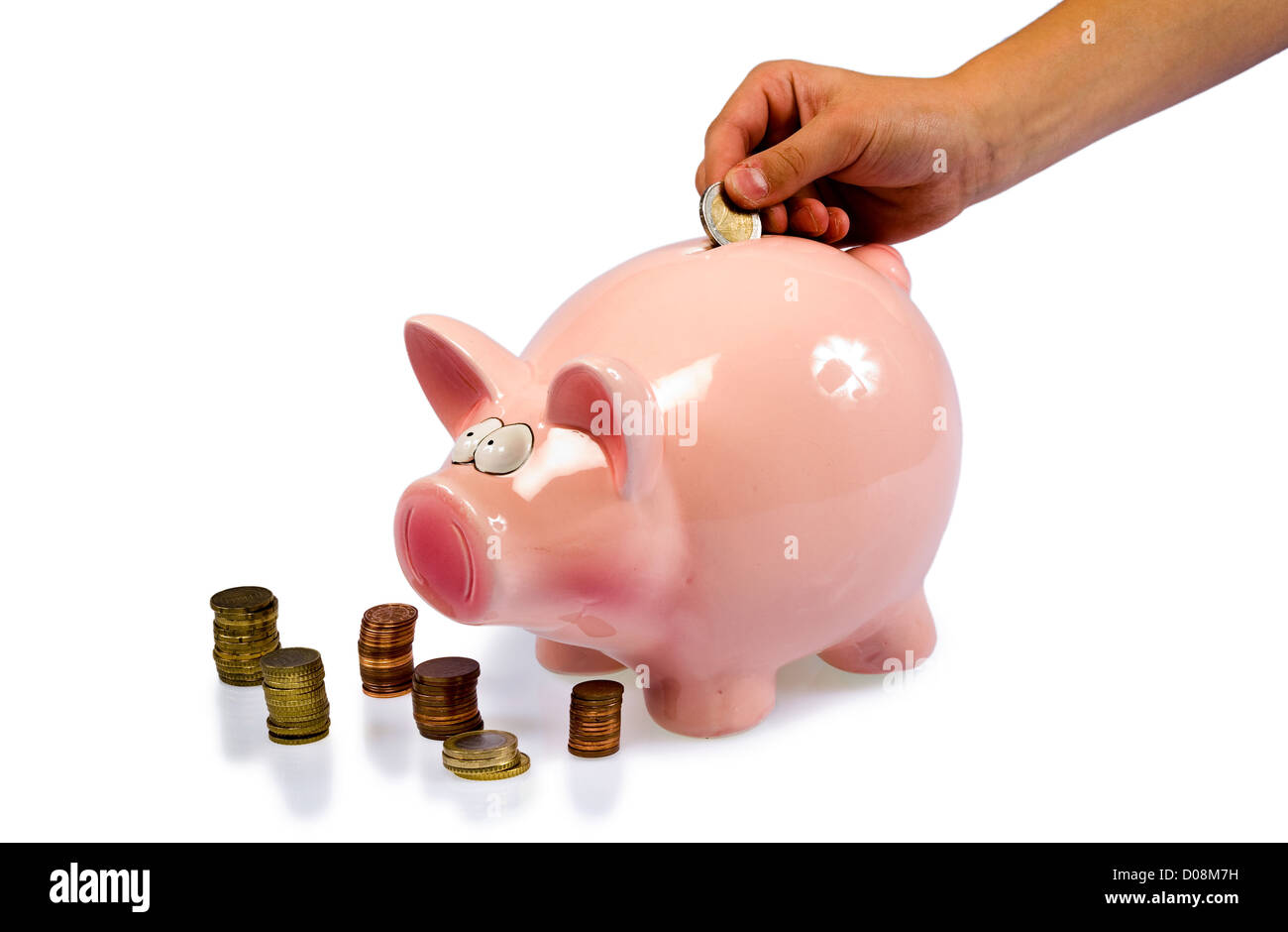 Une main est de mettre une pièce de 2 euros dans une économie pig Banque D'Images