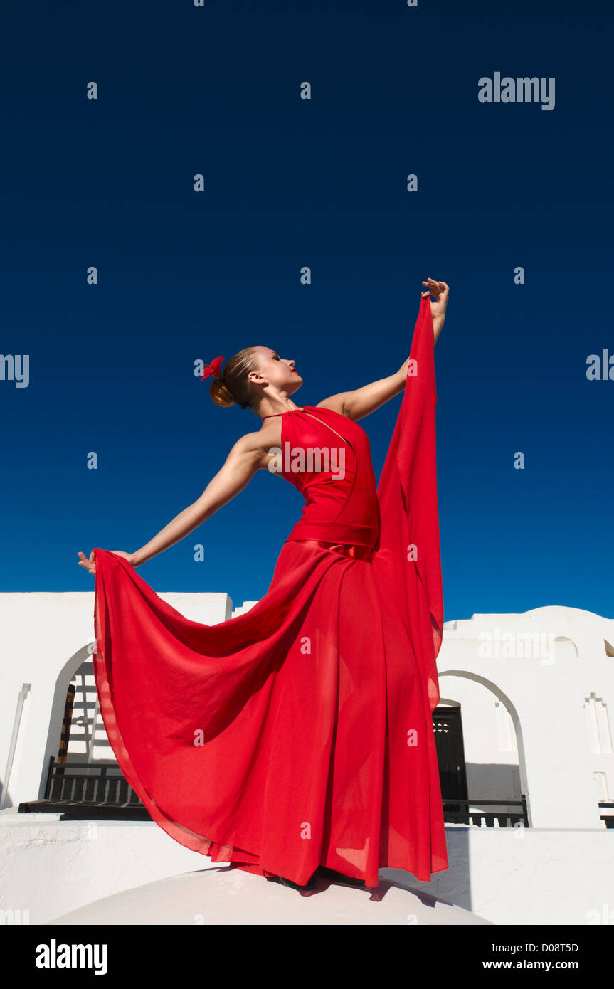 Danseuse de flamenco traditionnel attrayant portant robe rouge avec une fleur dans ses cheveux Banque D'Images