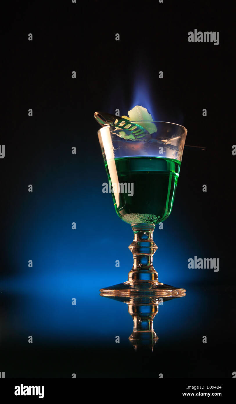 Un verre d'absinthe à la combustion sur le sucre. Banque D'Images