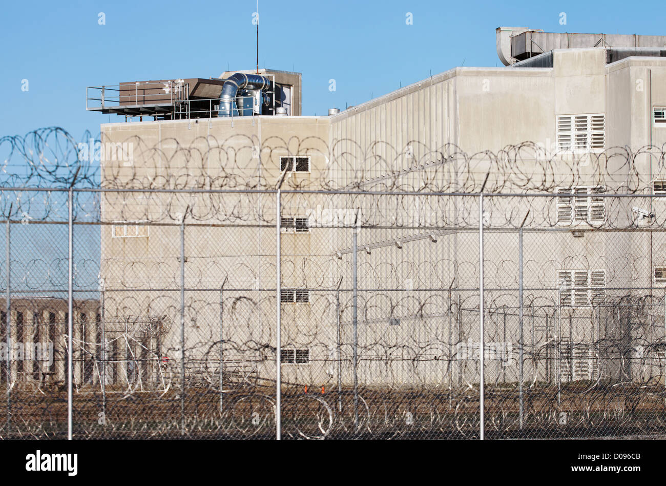 Un grand bâtiment dans un complexe pénitentiaire, avec une clôture en fil barbelé à l'établissement correctionnel. Banque D'Images