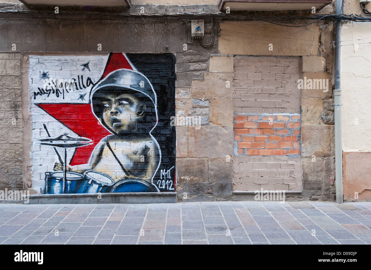 Street art de jeune garçon jouant de la batterie dans un helmut en face d'une étoile rouge communiste Banque D'Images