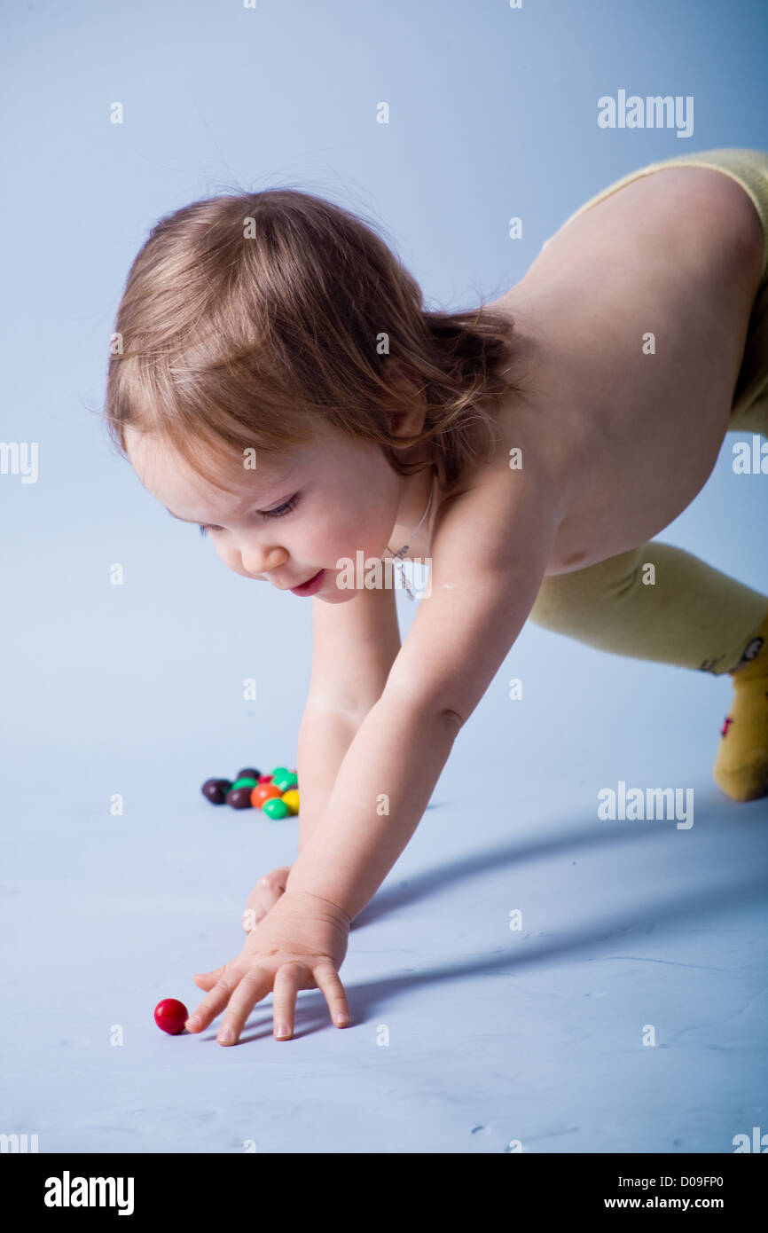 Kid girl atteindre petite balle Banque D'Images