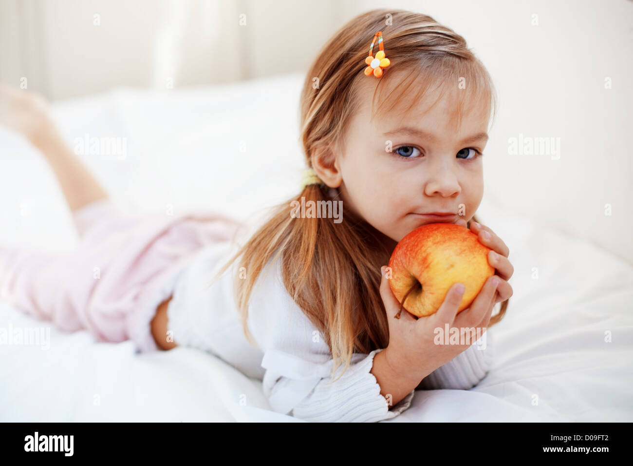 De l'enfant mignon occasionnel avec apple au lit Banque D'Images