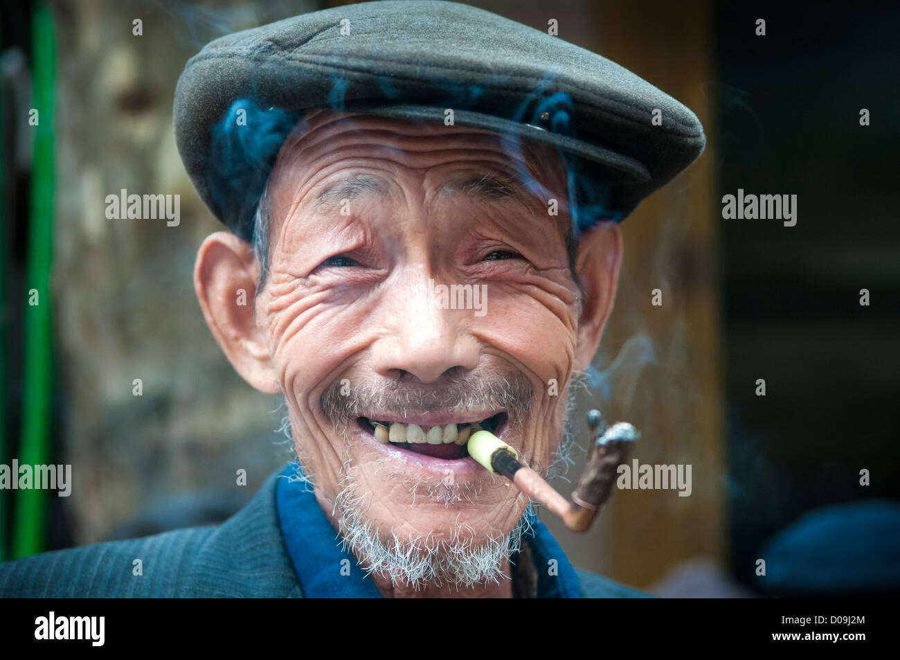 L'homme fume pipe tout en discutant avec des amis le jour du marché dans le village à la périphérie de Chengdu, province du Sichuan, Chine Banque D'Images
