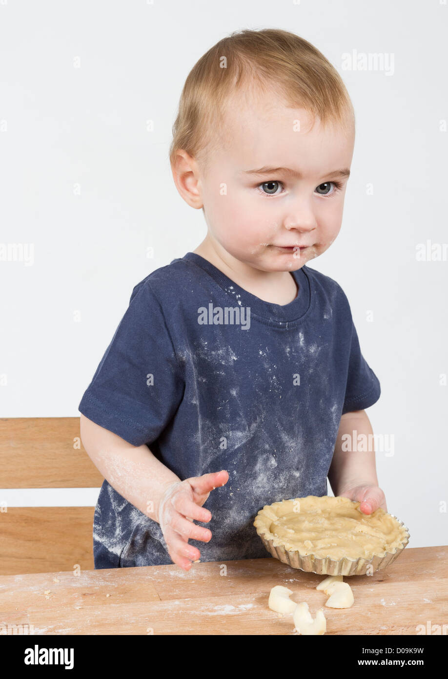 Les jeunes enfant faisant des cookies sur petit bureau en bois Banque D'Images