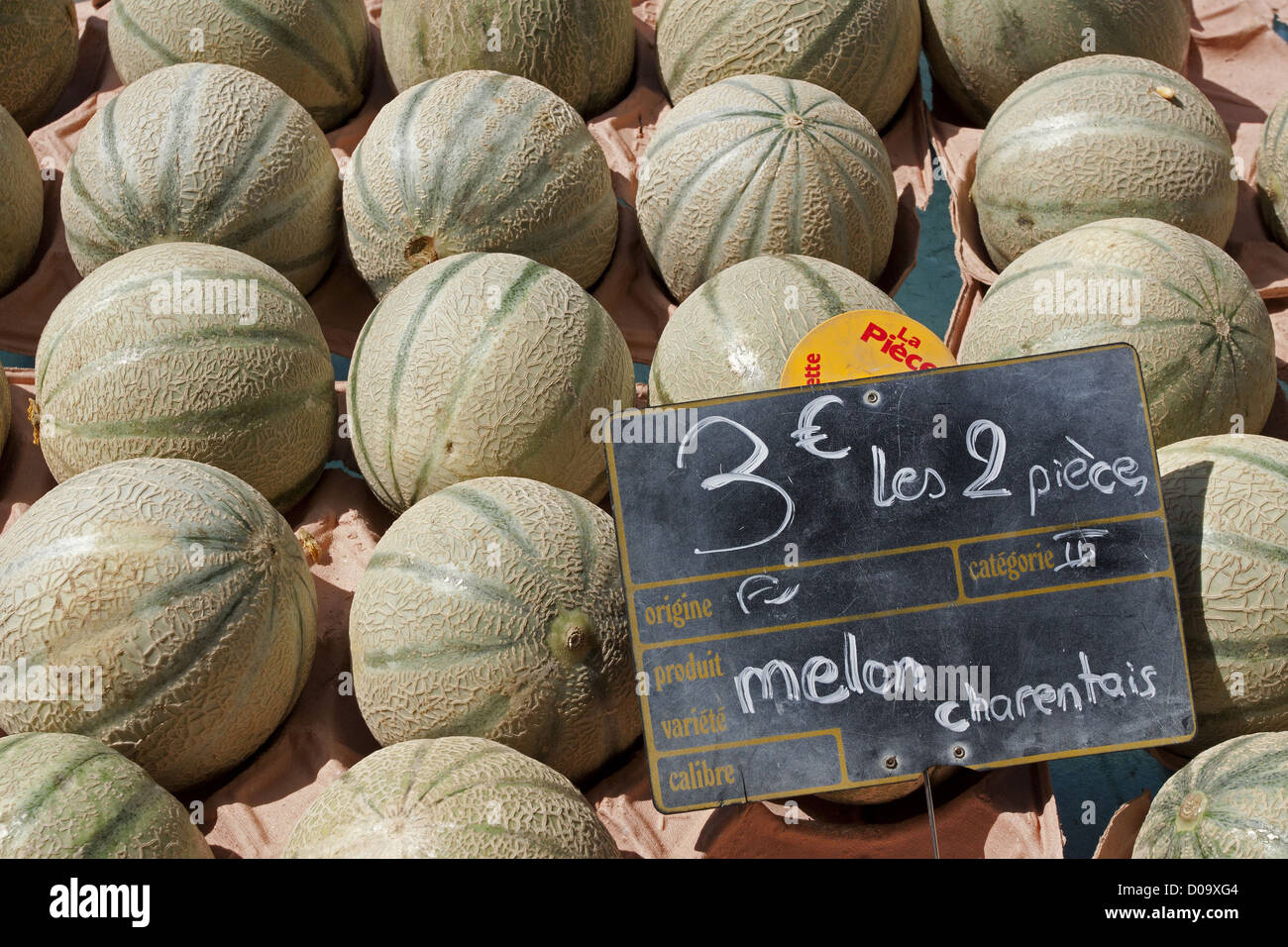 Les Melons CHARENTAIS SUR L'ÉTAL D'UN VENDEUR DE FRUITS SUR LE MARCHÉ D'ALLEVARD ISÈRE RHÔNE-ALPES FRANCE Banque D'Images