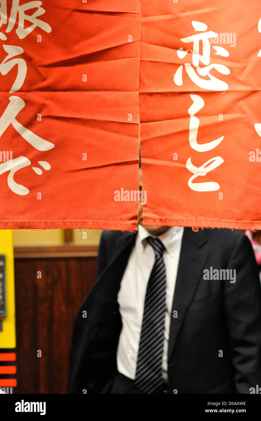 Un salaryman laissant un restaurant à Osaka, Japon. Banque D'Images