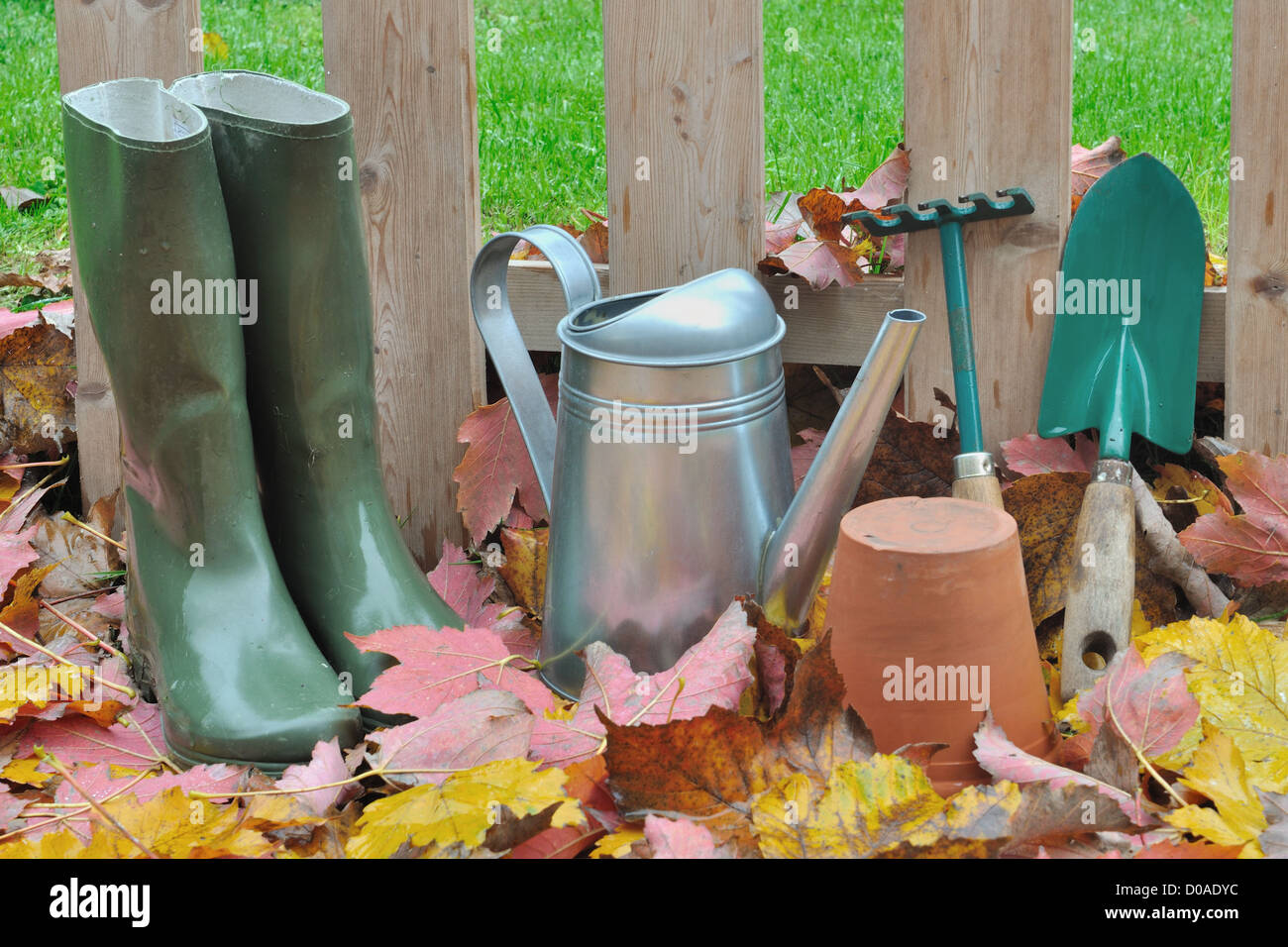 Les accessoires de jardin sur les feuilles mortes en face d'une clôture en bois dans le jardin Banque D'Images
