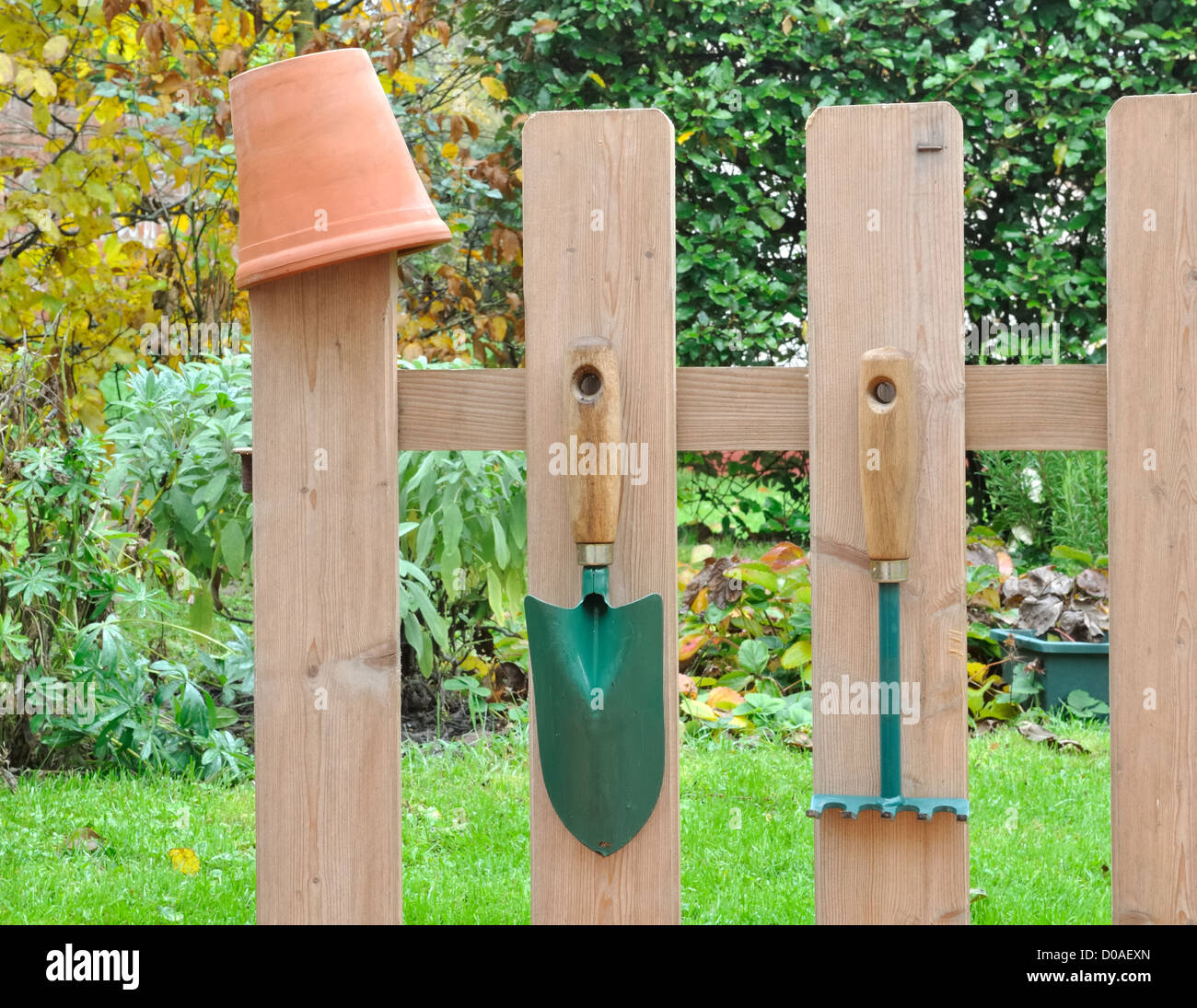 Outils de jardinage accroché à une clôture en bois dans le jardin Banque D'Images