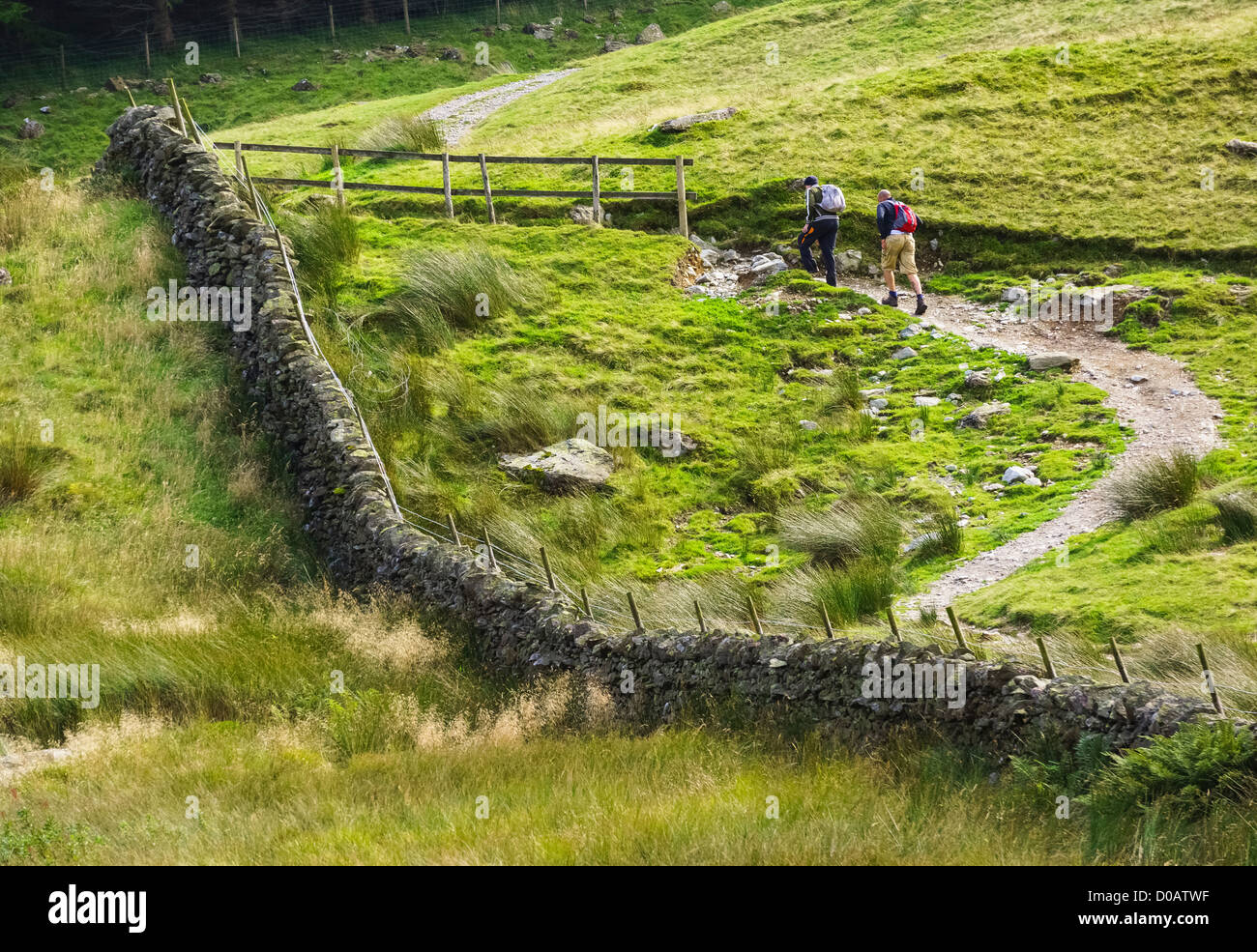 Deux randonneurs à monter une colline vers le parking à Haweswater dans le Lake District. Banque D'Images