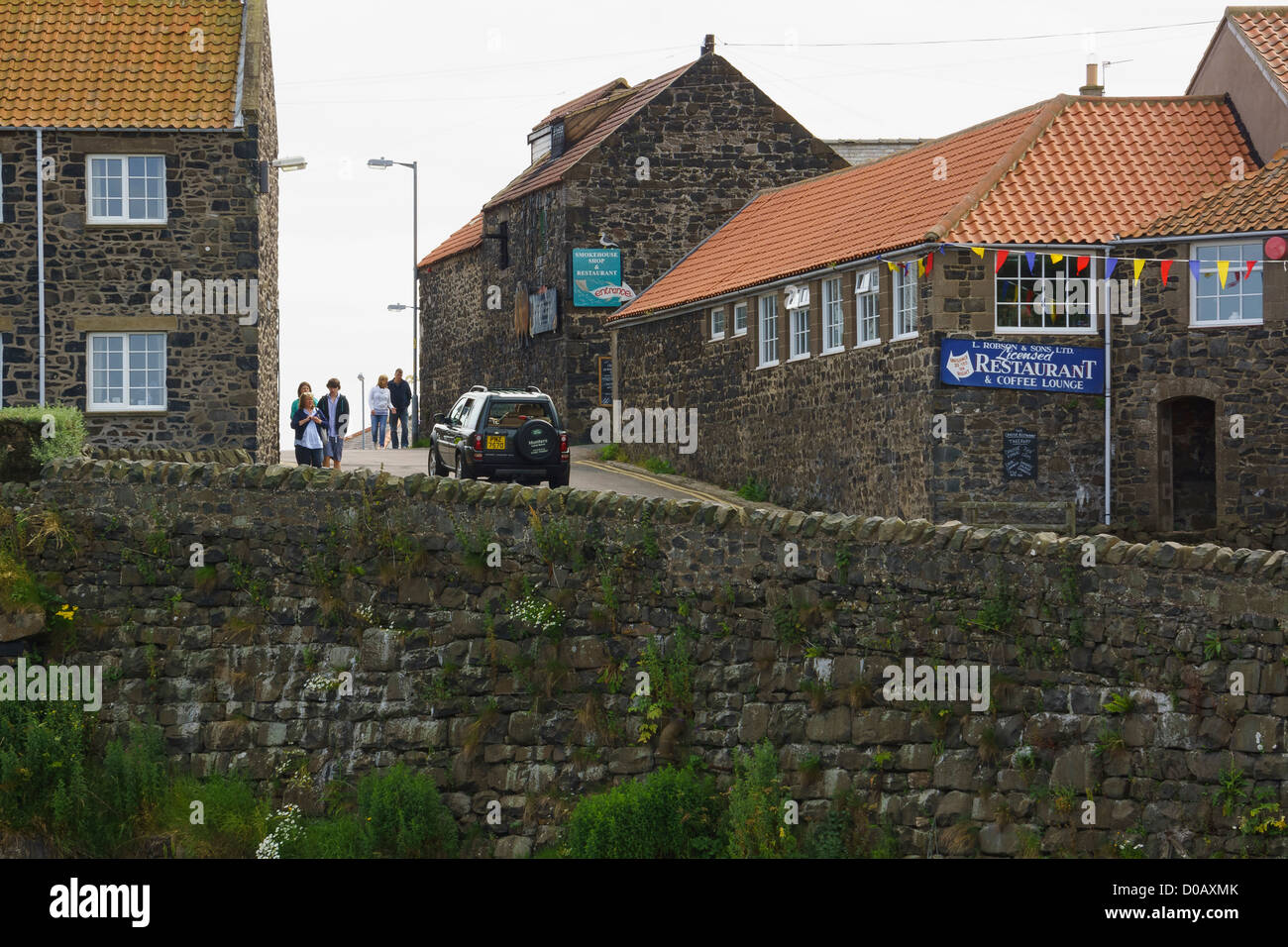 Le vieux village de pêcheurs de Craster avec panneaux pour le smockhouse et restaurant. Banque D'Images