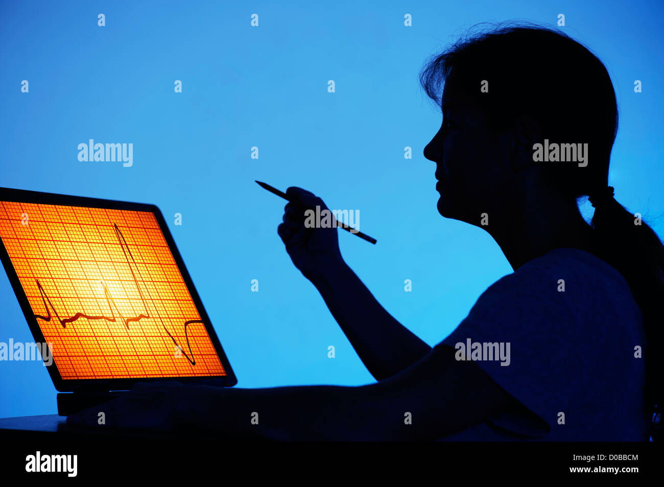 Femme médecin l'étude sur l'écran de l'ordinateur d'un électrocardiogramme. Banque D'Images