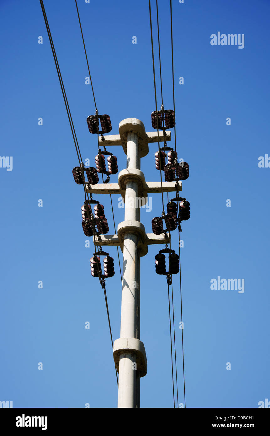 Des transformateurs électriques d'un poster à lignes électriques contre ciel bleu. Banque D'Images