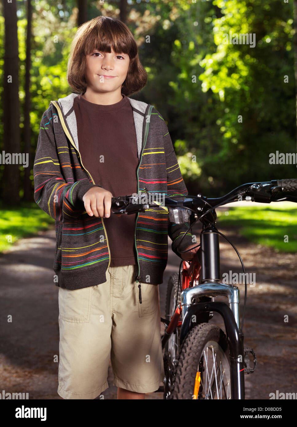 Portrait d'un enfant, garçon de dix ans, avec un vélo dans un parc. Banque D'Images