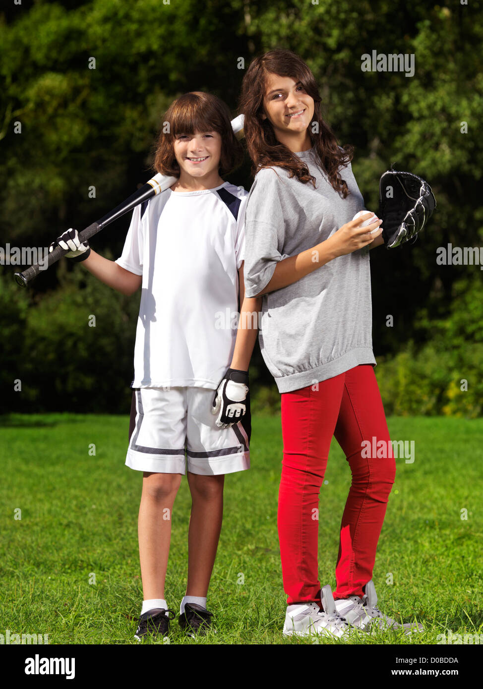 Portrait de deux enfants souriants, frère et soeur, 10 et 13, pratiquer le baseball, le style de vie en plein air de l'été actif. Banque D'Images