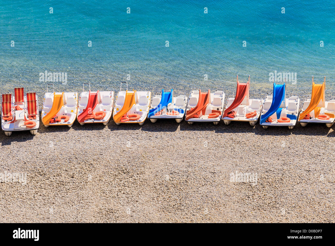 Pédalos colorés sur une plage de galets Banque D'Images