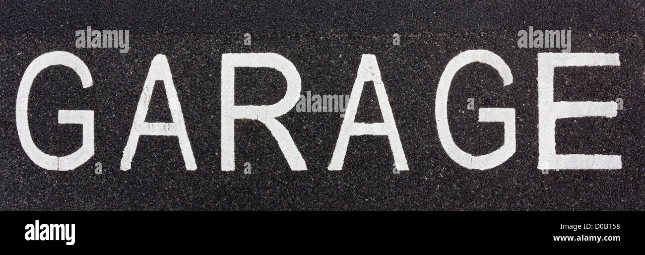 Inscrivez-garage peint sur la route avec la peinture blanche Banque D'Images