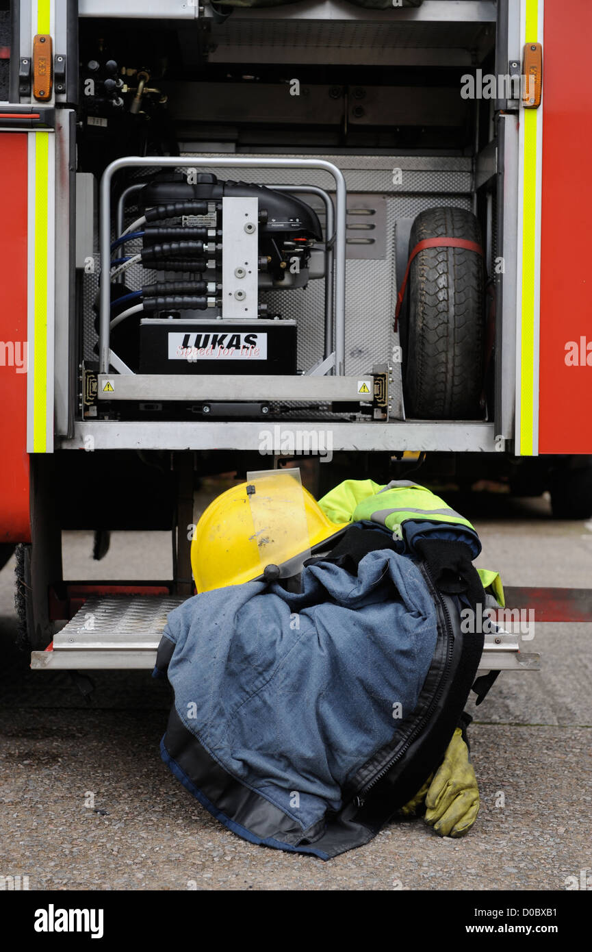 Re. Fireman de white watch à Pontypridd Fire Station en S Wales - casque de protection anti-incendie au manteau et gants sur le plancher Banque D'Images