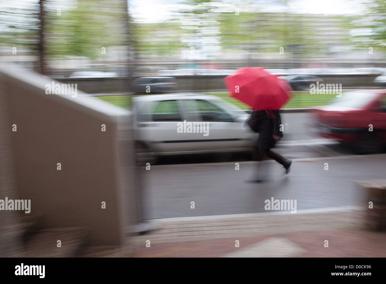 Femme à la hâte EN MARCHE DANS LA RUE SOUS LA PLUIE LE STRESS DANS LA VILLE FRANCE Banque D'Images