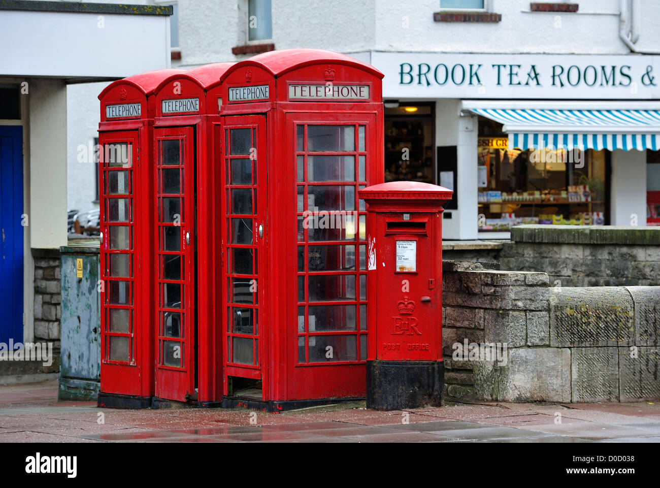 Téléphone rouge anglais traditionnels et boîtes bureaudeposte pillar box sur trottoir en ville rue en Angleterre, Royaume-Uni Banque D'Images