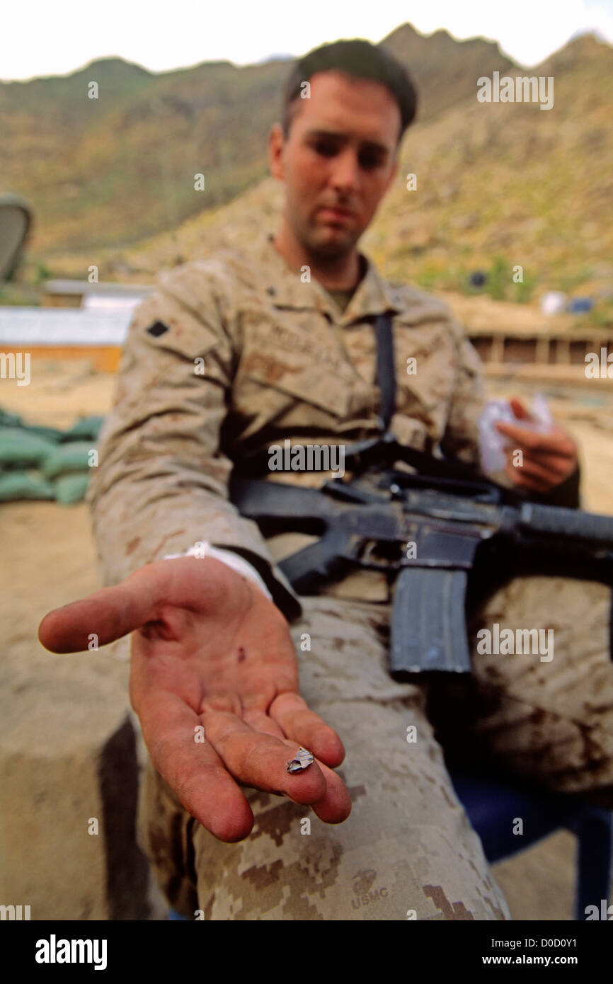 Un Marine américain montre un morceau d'une balle retirée de son poignet après un échange de tirs Banque D'Images