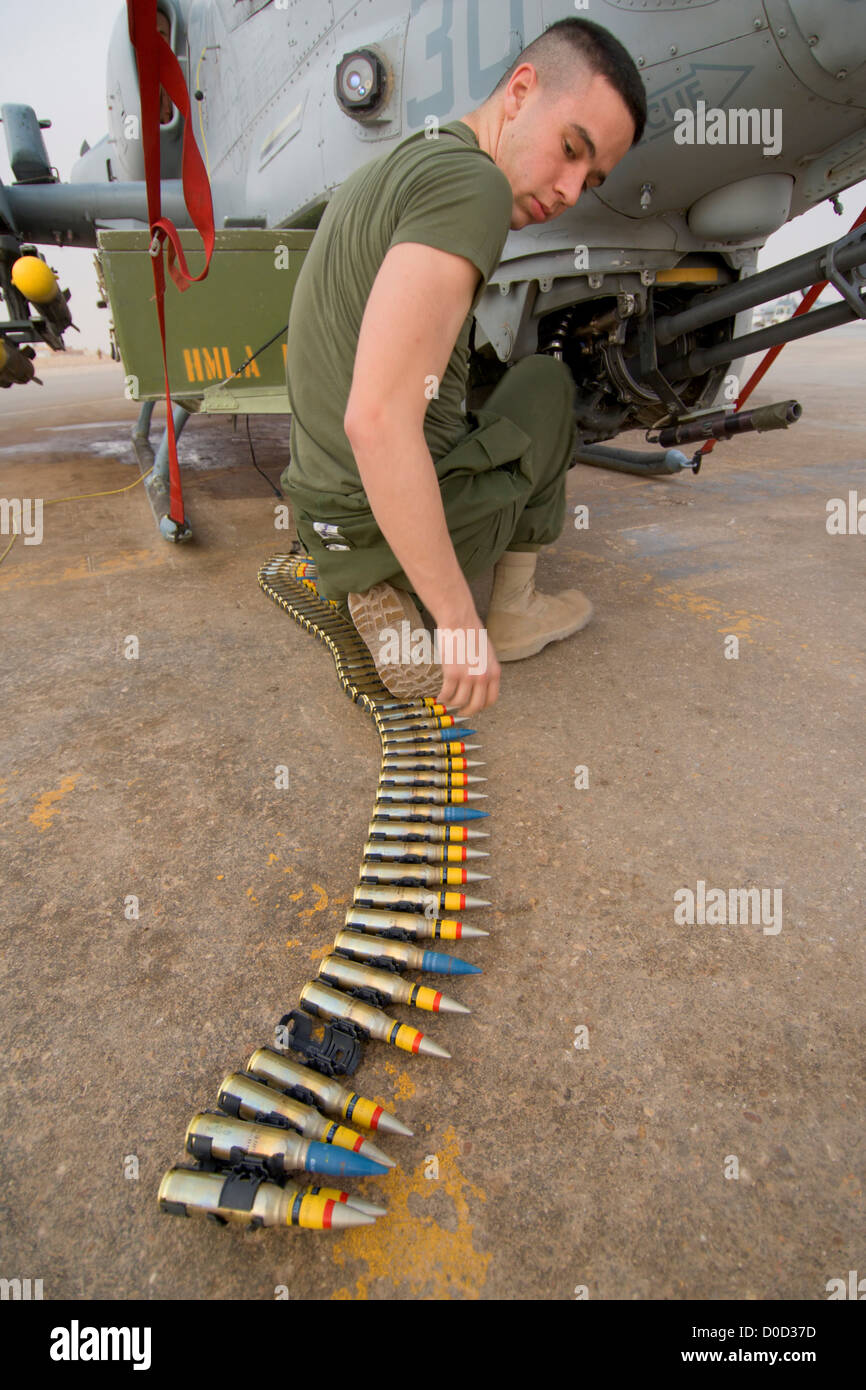 Un technicien d'armes de l'US Marine Corps 20mm de hauteur des charges explosifs sur AH-1W Super Cobra hélicoptère attaque Al Asad Air Base Banque D'Images