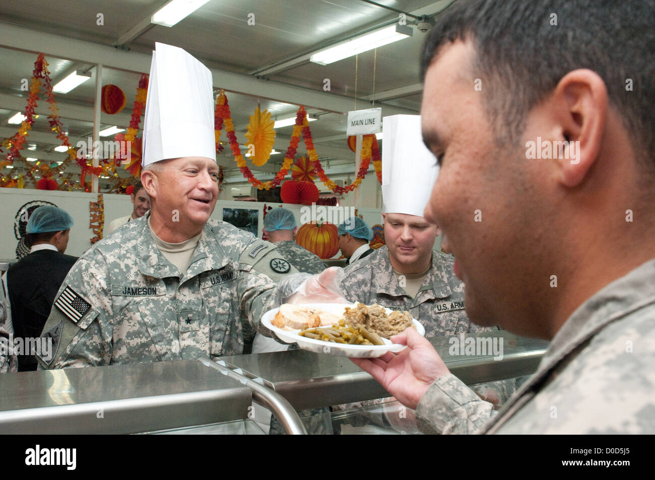 Brig. Gen. Bud R. Jameson Jr., commandant général du 316th Sustainment Command (expéditionnaire), remet un repas de Thanksgiving à un soldat au Camp Arifjan, Koweït, le 22 novembre 2012. Le repas s’inscrivait dans une tradition des fêtes pour soutenir les soldats déployés pendant la saison. Banque D'Images