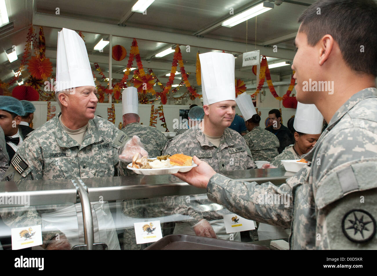 Brig. Gen. Bud R. Jameson Jr. du 316th Sustainment Command (Expeditionary) sert un repas de Thanksgiving au personnel militaire au Camp Arifjan, Koweït. Le repas s’inscrivait dans une tradition festive visant à maintenir le moral pendant le déploiement. Banque D'Images