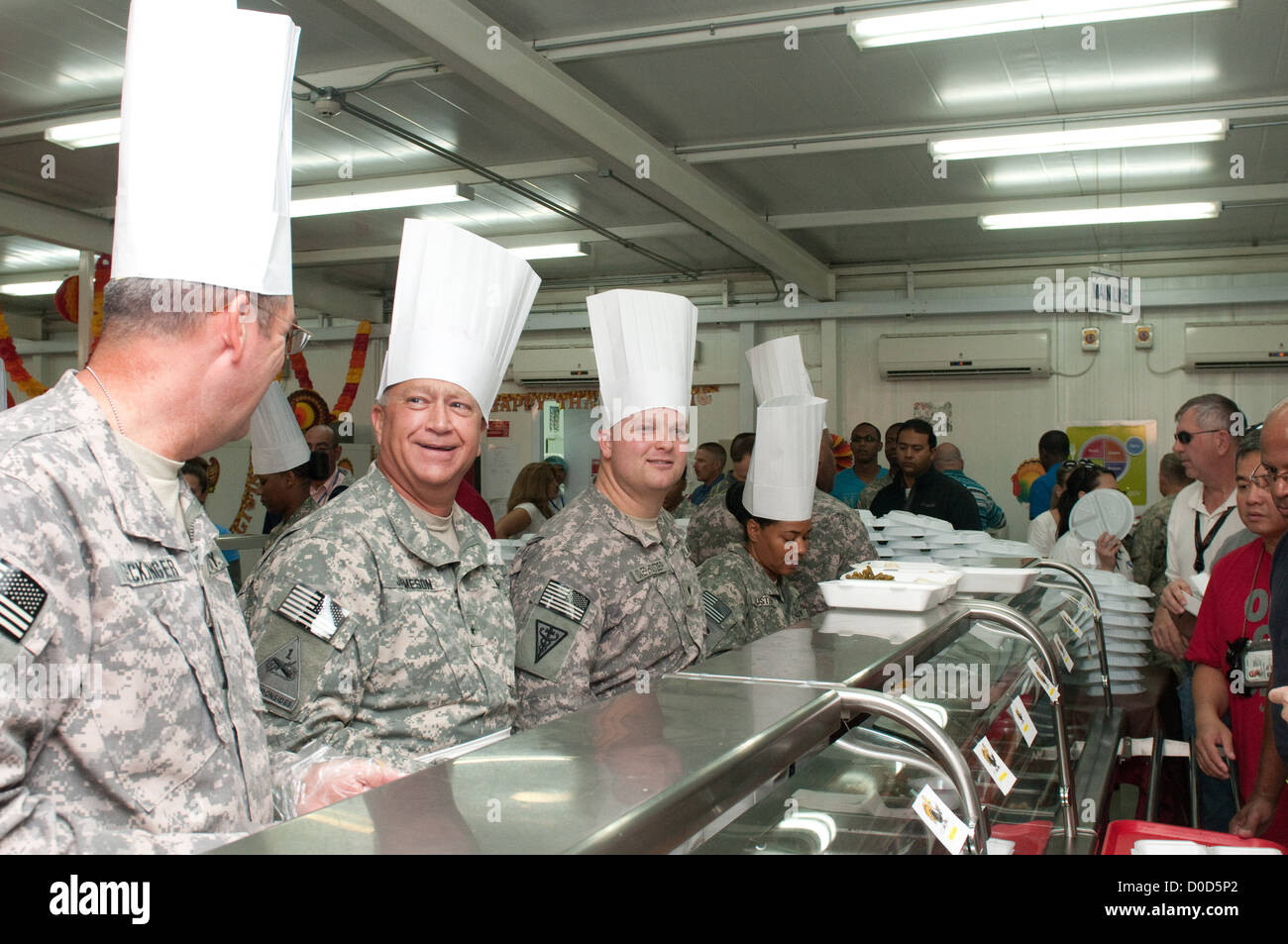 Brig. Gen. Bud R. Jameson Jr. du 316th Sustainment Command (Expeditionary) sert le dîner de Thanksgiving aux soldats au Camp Arifjan, Koweït, partageant un moment de lumière avec les troupes. Banque D'Images