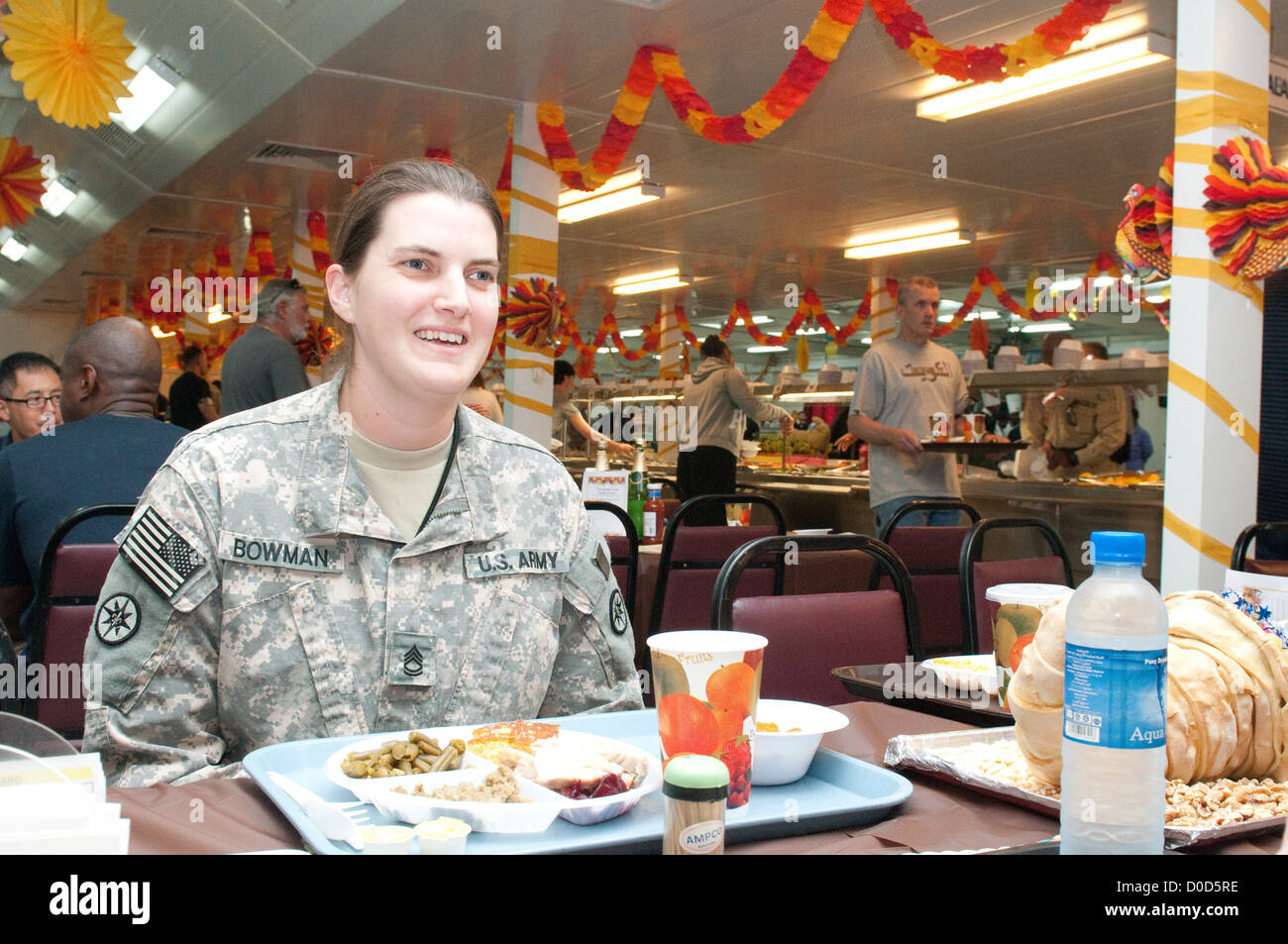 La Sgt. De 1re classe Renee Bowman, du 316e Commandement de la durabilité (expéditionnaire), parle avec un ami de son lieu d’affectation avant de profiter du dîner de Thanksgiving au Camp Arifjan, Koweït, soulignant l’équilibre du service militaire et des moments personnels. Banque D'Images
