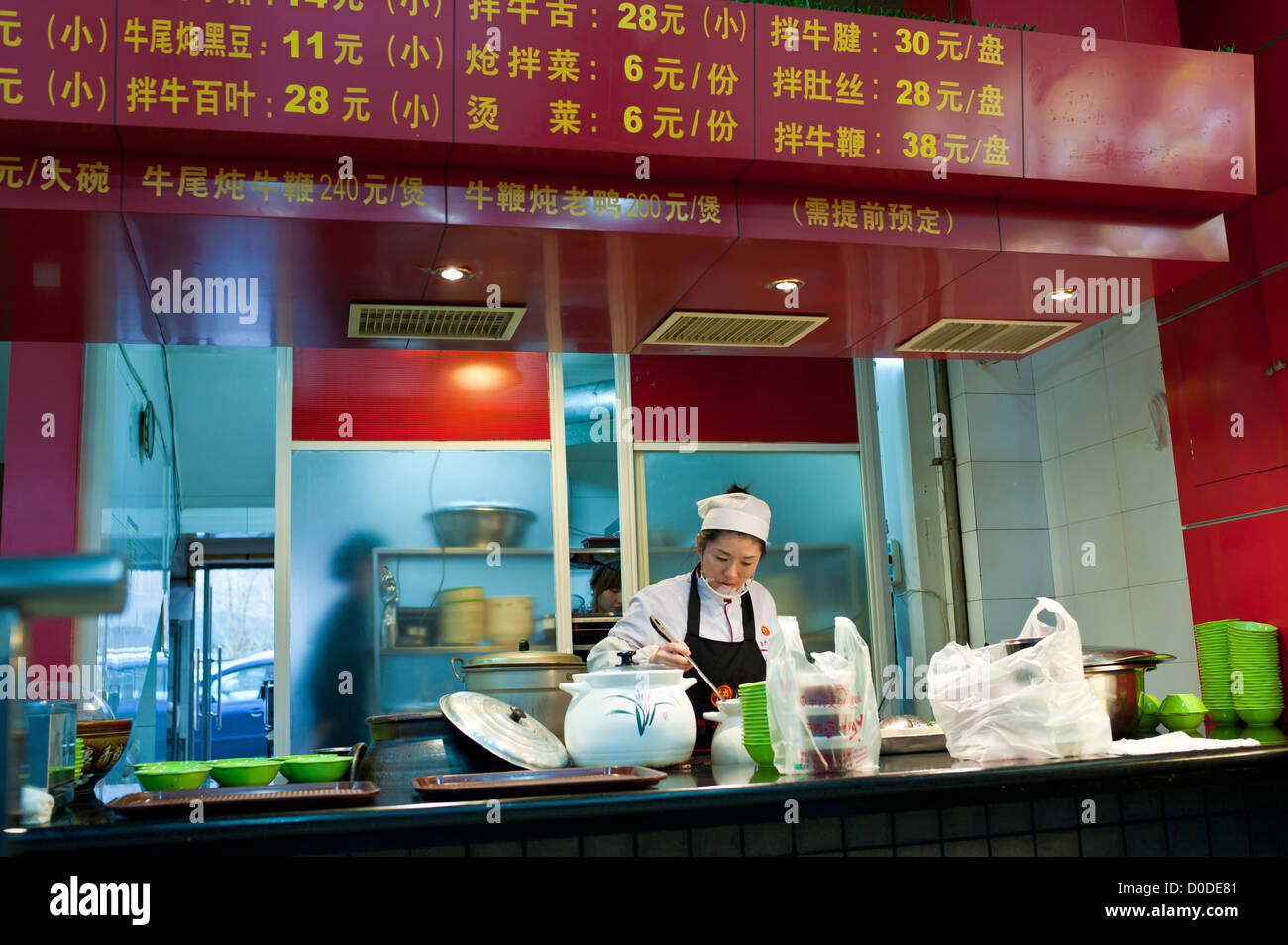 Une femme prépare la nourriture dans un chinois à emporter, à Harbin Banque D'Images