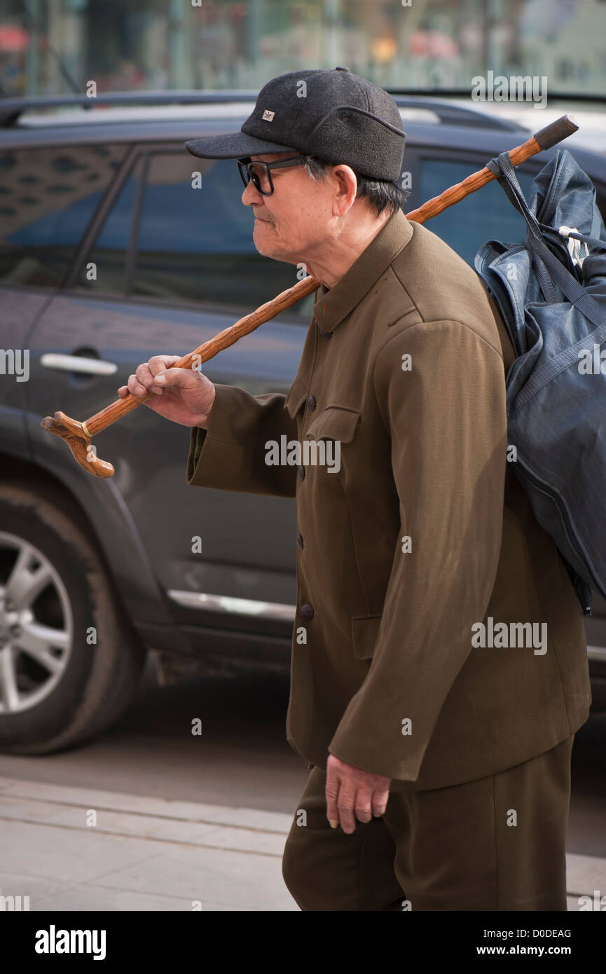 Un vieil homme chinois Mao dans un costume avec une canne et de sac Banque D'Images