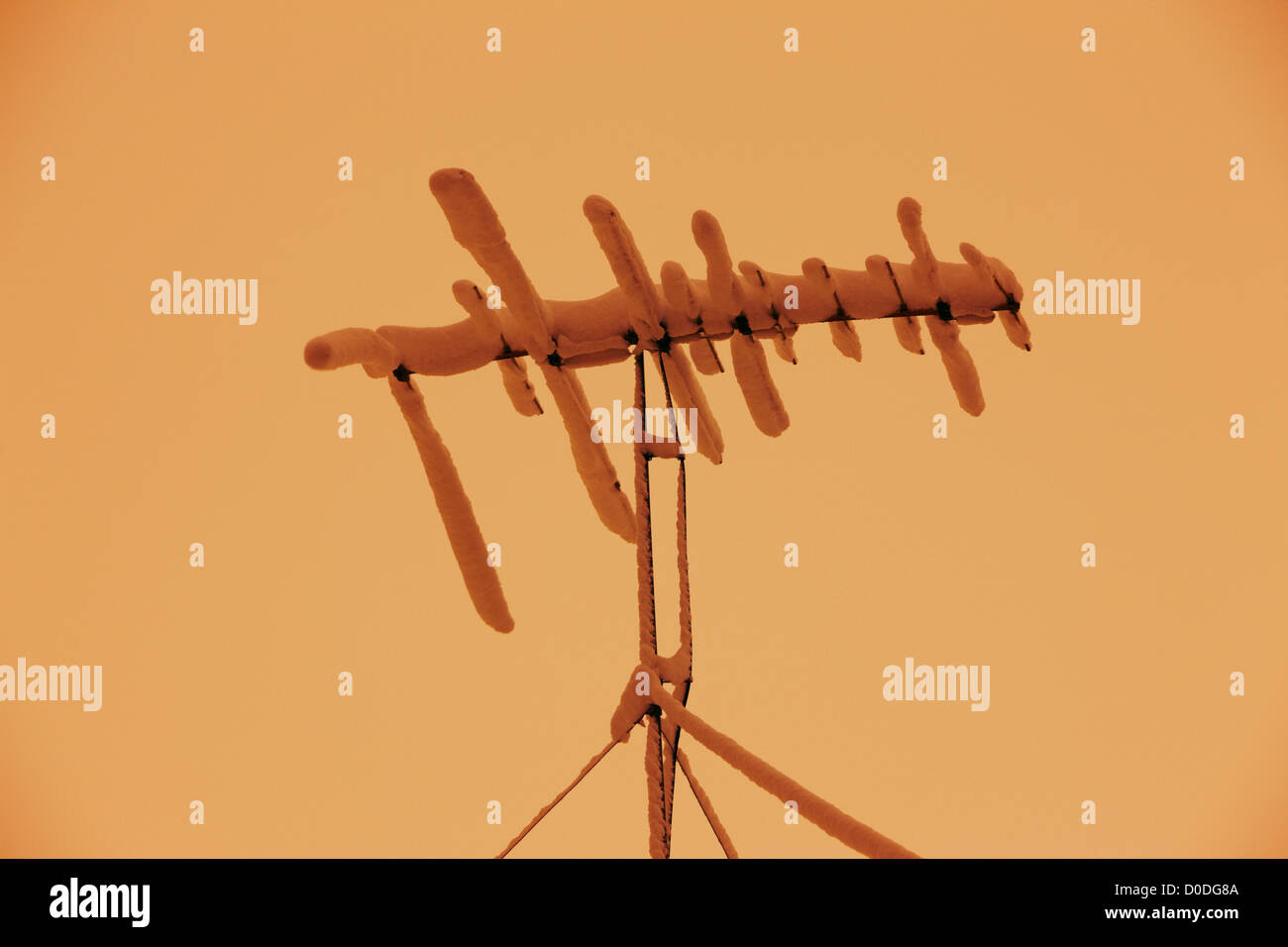 Antenne de télévision recouverte de neige et givre pendant un blizzard avant l'aube. Banque D'Images