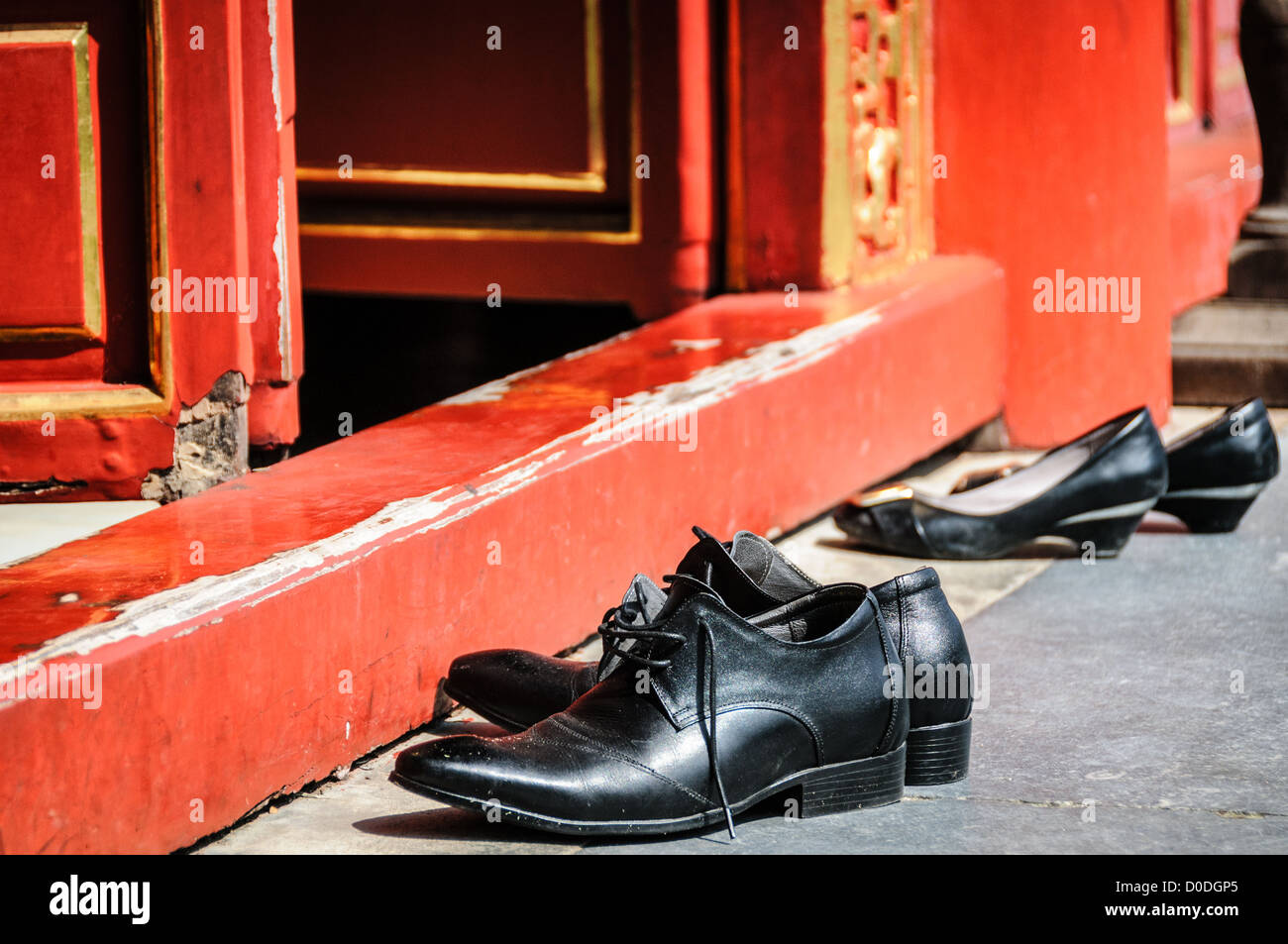 To Mieu Temple Shoes Off Hue Vietnam // HUE, Vietnam — les visiteurs doivent enlever leurs chaussures pour entrer dans le temple To Mieu à la ville impériale de Hue, Vietnam. Palais clos et fortifié, le complexe comprend la Cité interdite pourpre, qui était le sanctuaire intérieur de la maison impériale, ainsi que des temples, des cours, des jardins et d'autres bâtiments. Une grande partie de la ville impériale a été endommagée ou détruite pendant la guerre du Vietnam. Il est maintenant classé au patrimoine mondial de l'UNESCO. Banque D'Images