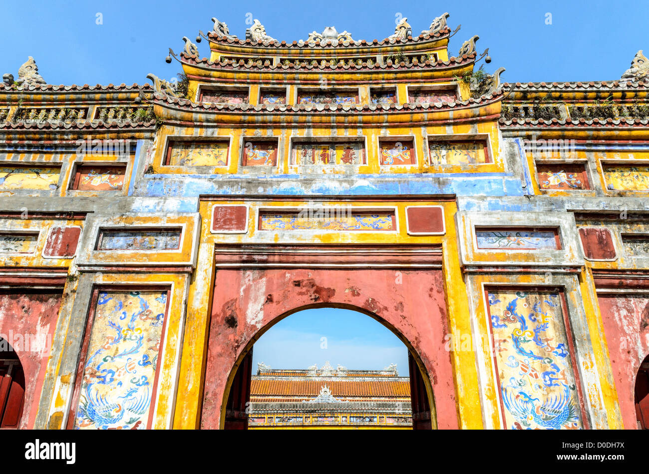 HUE, Vietnam — Une porte peinte à la ville impériale de Hue, Vietnam. Palais clos et fortifié, le complexe comprend la Cité interdite pourpre, qui était le sanctuaire intérieur de la maison impériale, ainsi que des temples, des cours, des jardins et d'autres bâtiments. Une grande partie de la ville impériale a été endommagée ou détruite pendant la guerre du Vietnam. Il est maintenant classé au patrimoine mondial de l'UNESCO. Cette porte était une entrée de la résidence Dien Tho. Construit en 1804, ce complexe était le logement de la grand-mère de la reine mère ou de l'empereur. Banque D'Images