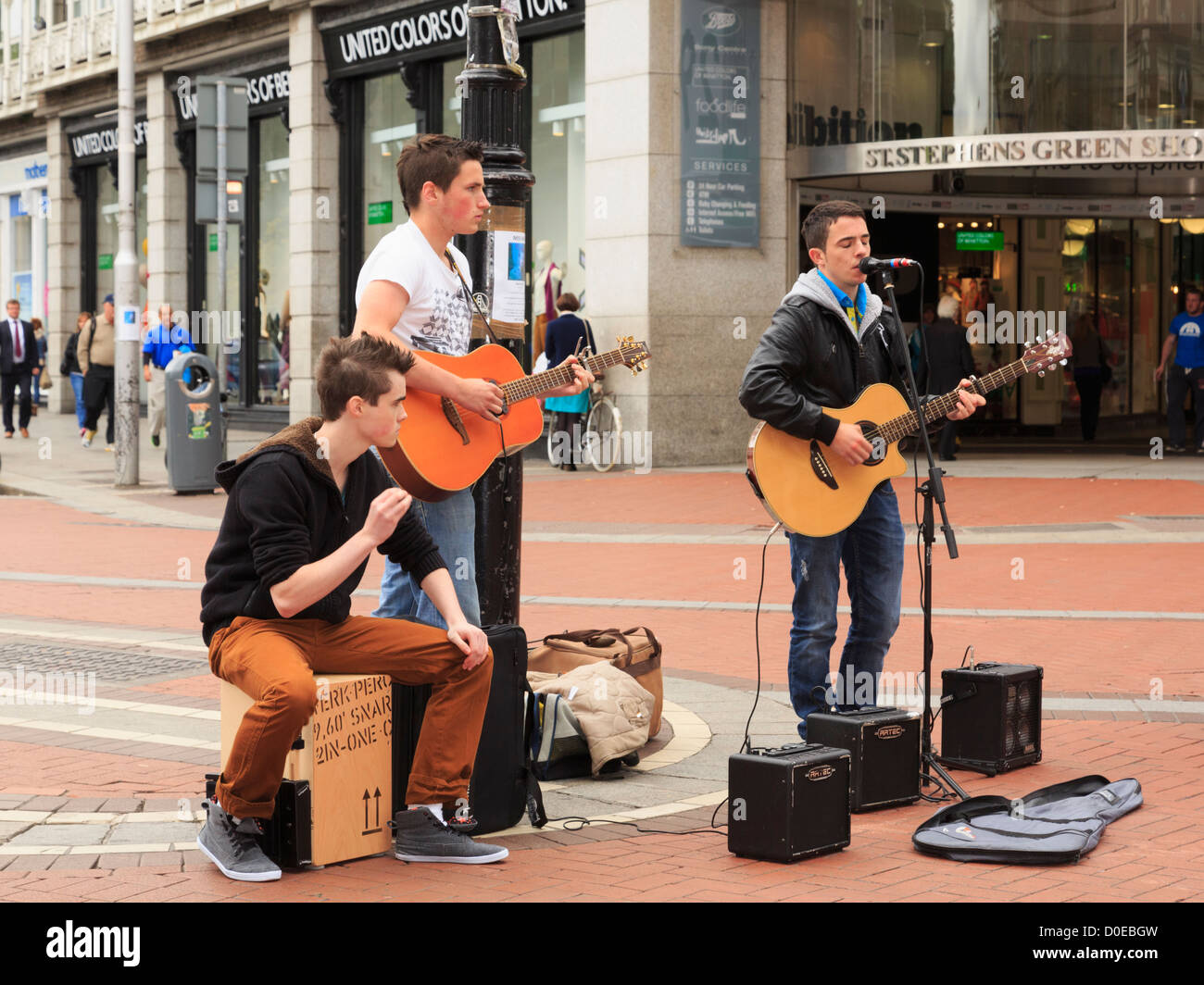 Scène de rue typique avec trois musiciens joueurs de guitare de la rue dans le centre-ville sur Grafton Street Dublin Irlande Eire Banque D'Images