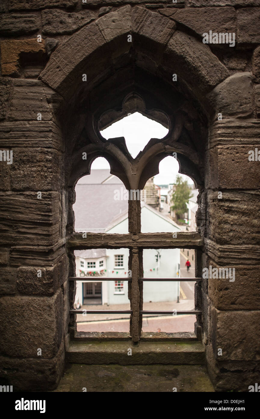 CAERNARFON, Pays de Galles - une fenêtre donnant sur la ville au château de Caernarfon au nord-ouest du pays de Galles. Un château s'élevait à l'origine sur le site remontant à la fin du xie siècle, mais à la fin du 13e siècle, le Roi Edward J'ai commandé une nouvelle structure qui se tient à ce jour. Il possède des tours et est l'un des mieux conservés de la série de châteaux-QUE J'ai commandé. Banque D'Images