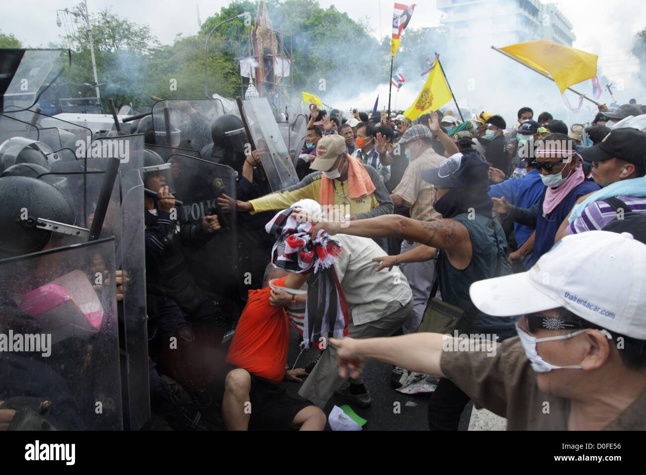 24 Nov 2012 , Bangkok , Thaïlande . Des policiers anti-émeute thaïlandaise en conflit avec les manifestants pendant une manifestation. La police thaïlandaise a tiré des gaz lacrymogènes et arrêté des dizaines de personnes alors que les tensions ont éclaté à un anti-Pitak Siam protestation du gouvernement . Le groupe Pitak Siam, qui a parrainé la manifestation, a cité la corruption présumée du gouvernement et anti-monarchiste des éléments au sein du parti au pouvoir comme motif de la protestation. La police a utilisé des gaz lacrymogènes et de bâton contre les manifestants. Banque D'Images