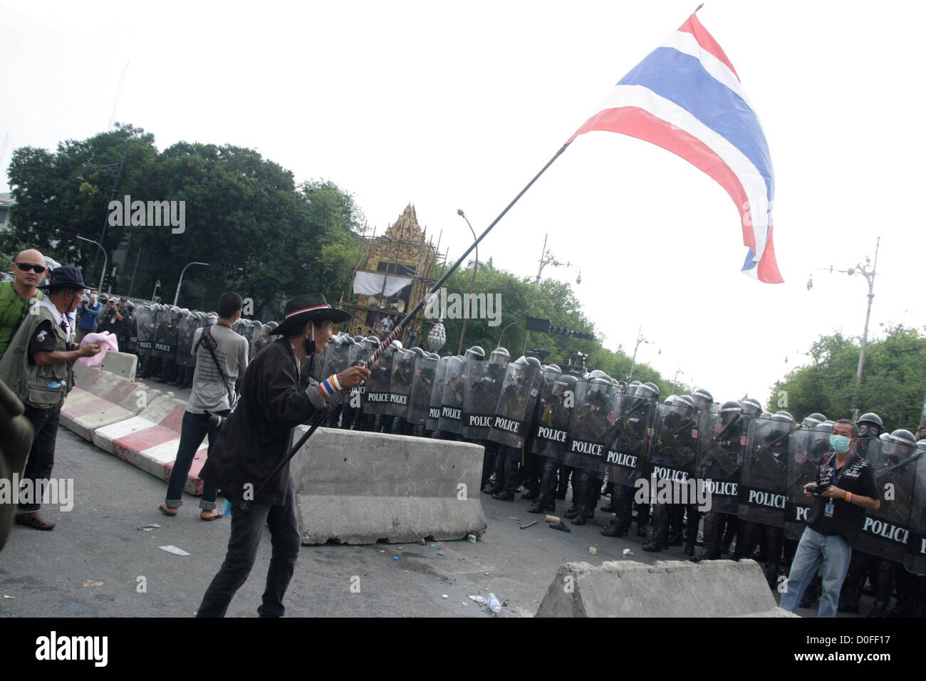 24 Nov 2012 , Bangkok , Thaïlande . Des policiers anti-émeutes et des manifestants thaïlandais au cours d'une manifestation. La police thaïlandaise a tiré des gaz lacrymogènes et arrêté des dizaines de personnes alors que les tensions ont éclaté à un anti-Pitak Siam protestation du gouvernement . Le groupe Pitak Siam, qui a parrainé la manifestation, a cité la corruption présumée du gouvernement et anti-monarchiste des éléments au sein du parti au pouvoir comme motif de la protestation. La police a utilisé des gaz lacrymogènes et de bâton contre les manifestants. Banque D'Images