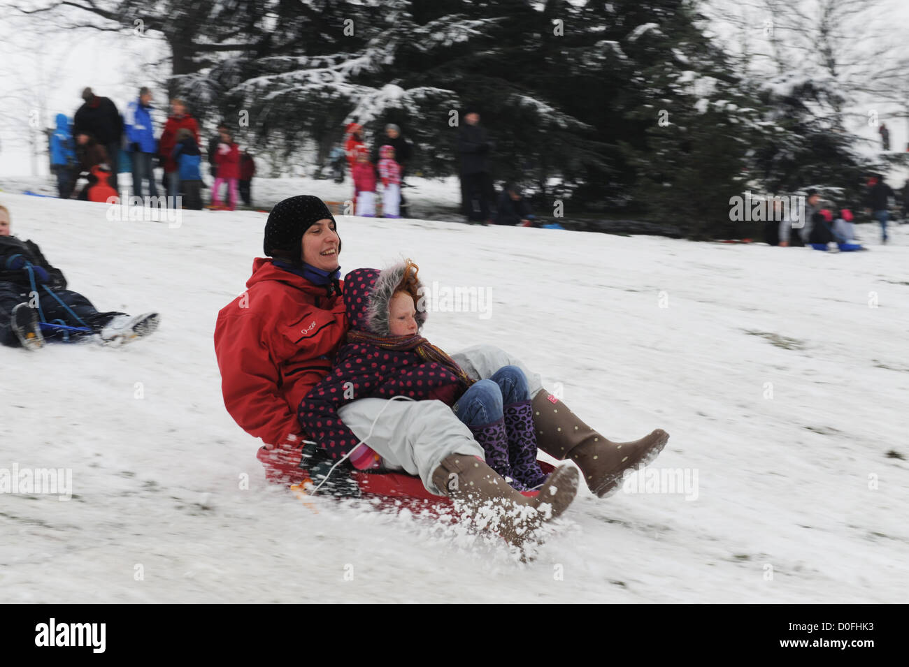 Mère et fille de la luge sur les pentes dans le parc de Greenwich, Londres , Royaume-Uni Banque D'Images