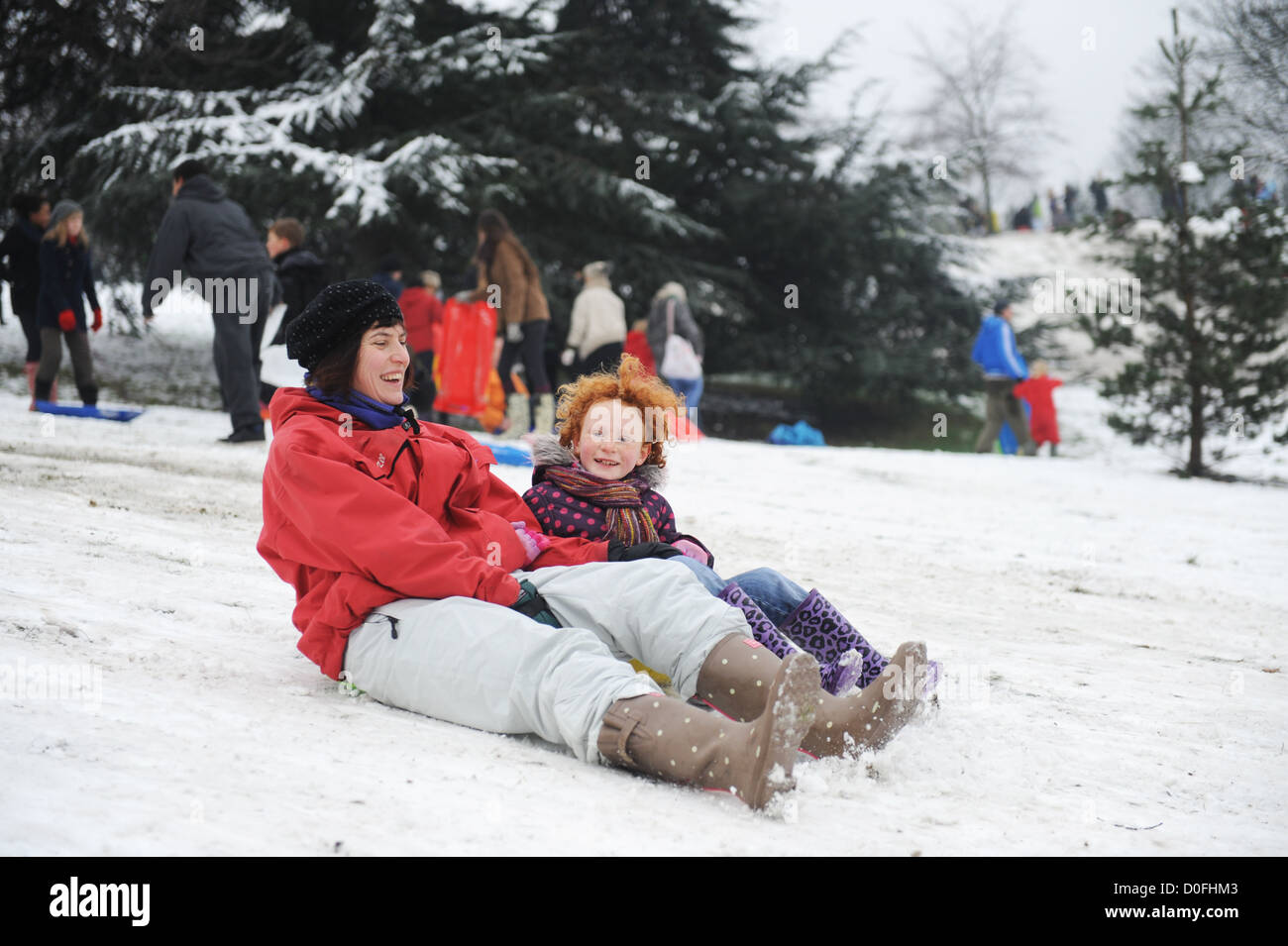 Mère et fille de la luge sur les pentes dans le parc de Greenwich, Londres , Royaume-Uni Banque D'Images