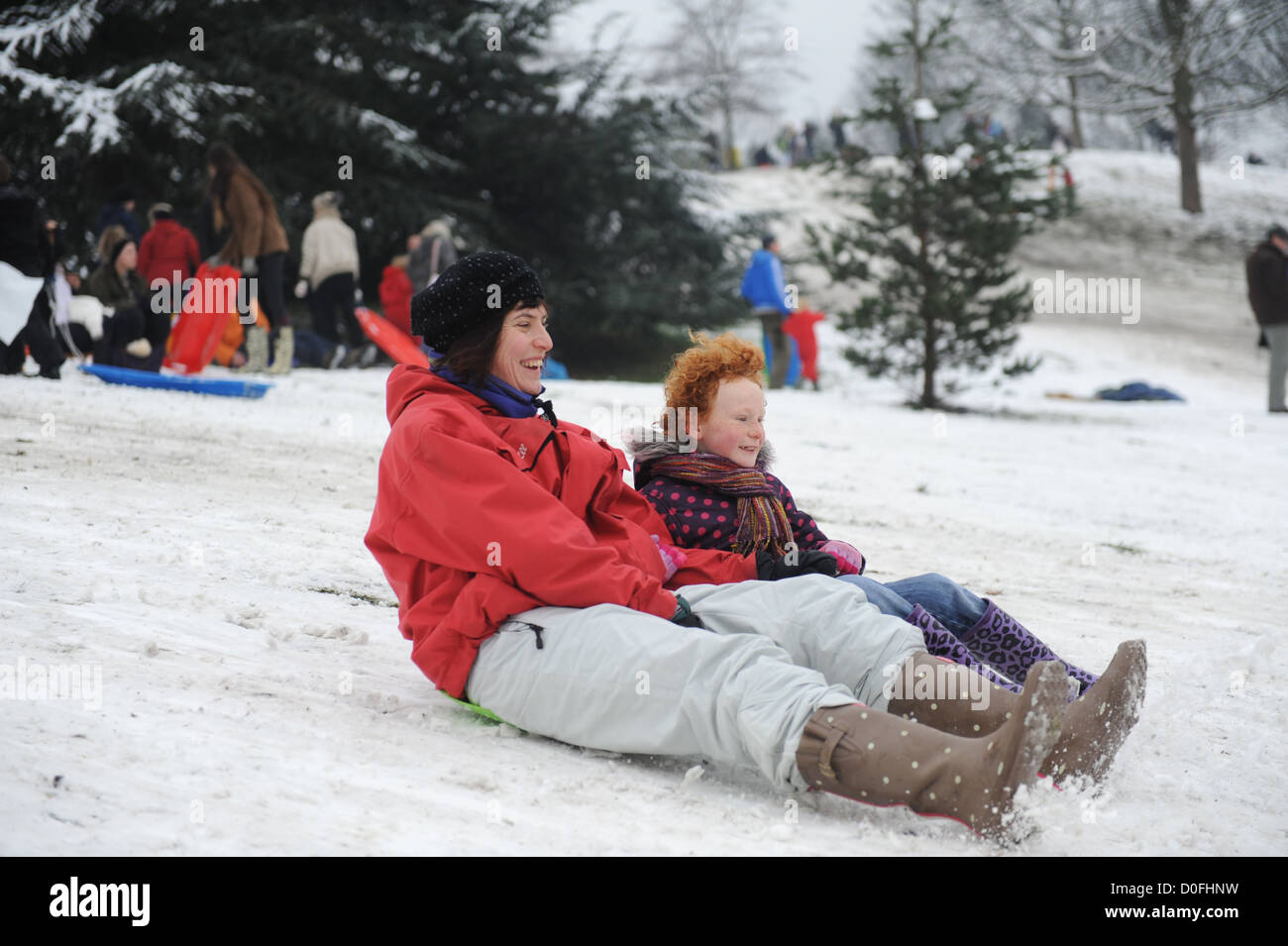 Mère et fille de la luge sur les pentes dans le parc de Greenwich, Londres , Royaume-Uni Banque D'Images